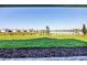 Expansive backyard view with lush green grass, lake, and neighborhood in the distance, perfect for outdoor enjoyment at 8375 E Windbound Ct Ct, Sarasota, FL 34240
