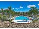 Resort-style community pool surrounded by palm trees and lounge chairs at 8375 E Windbound Ct Ct, Sarasota, FL 34240