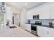 Gourmet kitchen boasts stainless steel appliances, white cabinetry, and modern fixtures at 8375 E Windbound Ct Ct, Sarasota, FL 34240