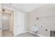 Well-lit laundry room with gray wood-look floors, a utility sink, door to hall, and overhead storage rack at 8375 E Windbound Ct Ct, Sarasota, FL 34240