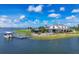 Waterfront view of community clubhouse featuring a dock, seating, an American flag, and lush landscaping at 8375 E Windbound Ct Ct, Sarasota, FL 34240