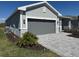 Home exterior featuring a paved driveway, two-car garage, and green lawn at 8644 Saint Kitts Cir, Englewood, FL 34224