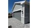 Two-car garage with a paved driveway and gray siding, and black outdoor lights at 8644 Saint Kitts Cir, Englewood, FL 34224