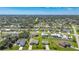 Wide aerial perspective of a residential community; houses with green lawns and mature trees dot the landscape at 9423 El Campo Ave, Englewood, FL 34224