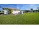 Expansive backyard features lush green grass, an outdoor kitchen area, and leads to the property's exterior at 9423 El Campo Ave, Englewood, FL 34224