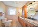 Well-lit bathroom featuring dual sinks, granite countertops, and wood cabinetry at 9423 El Campo Ave, Englewood, FL 34224