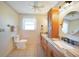 Well-lit bathroom featuring dual sinks, granite countertops, and wood cabinetry at 9423 El Campo Ave, Englewood, FL 34224