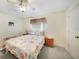 Bright bedroom with ceiling fan features a light-filled window and soft carpeting at 9423 El Campo Ave, Englewood, FL 34224