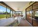 Relax in the bright lanai featuring comfortable seating and lovely outdoor views through the glass-enclosed space at 9423 El Campo Ave, Englewood, FL 34224