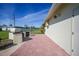 Brick patio with outdoor kitchen area, positioned alongside a house with outdoor lighting and access door at 9423 El Campo Ave, Englewood, FL 34224