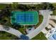 Aerial view featuring tennis court surrounded by lush landscaping and neighborhood streets at 10310 Coral Landings Ct # 98, Placida, FL 33946