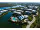 Community aerial view featuring residences, community pool, lake and well-manicured landscaping at 10310 Coral Landings Ct # 98, Placida, FL 33946