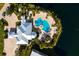 Aerial view showcasing the community pool, lush landscaping, and waterfront setting at 10310 Coral Landings Ct # 98, Placida, FL 33946