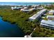 Aerial view of the condos with a community dock on the water, surrounded by lush landscaping at 10310 Coral Landings Ct # 98, Placida, FL 33946