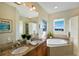 Bathroom with dual sinks, a soaking tub, and a large mirror with a great view at 10310 Coral Landings Ct # 98, Placida, FL 33946