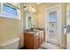 Bright bathroom with wood vanity, granite countertop, and a door to a private balcony at 10310 Coral Landings Ct # 98, Placida, FL 33946