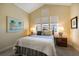 Bedroom with a vaulted ceiling, large windows, and two bedside tables at 10310 Coral Landings Ct # 98, Placida, FL 33946