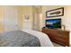 Cozy bedroom features a woven dresser with a TV and decorative artwork above it at 10310 Coral Landings Ct # 98, Placida, FL 33946