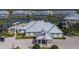 Exterior aerial view of clubhouse with metal roof, manicured landscaping, and lakeside view at 10310 Coral Landings Ct # 98, Placida, FL 33946