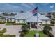 Front exterior of clubhouse featuring an American flag, crisp landscaping and manicured lawns at 10310 Coral Landings Ct # 98, Placida, FL 33946