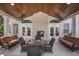 Covered outdoor patio area with a stone fireplace, comfortable seating, and ceiling fans at 10310 Coral Landings Ct # 98, Placida, FL 33946