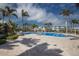 Beautiful community pool with ample lounge space and tropical landscaping on a sunny day at 10310 Coral Landings Ct # 98, Placida, FL 33946