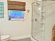 Updated bathroom with a stand up shower, nautical decor and a window with blind at 1011 Humboldt St, Englewood, FL 34224