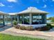 Waterfront home featuring a charming screened-in gazebo with seating and manicured landscaping at 1011 Humboldt St, Englewood, FL 34224