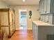 Hallway with wood floors leading to a half bath, decorative cabinets and a seahorse decoration at 1011 Humboldt St, Englewood, FL 34224