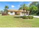 Well-maintained home featuring a spacious two-car garage, mature landscaping and a meticulously kept front lawn at 102 Rebel Ct, Rotonda West, FL 33947