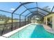 Swimming pool and screened-in lanai offer scenic lake views for the ultimate outdoor living experience at 102 Rebel Ct, Rotonda West, FL 33947