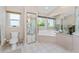 Bathroom featuring dual sinks, shower stall, soaking tub, and a large mirror at 10308 Euston Ave, Englewood, FL 34224