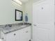 Stylish bathroom featuring a vanity with granite counters and a framed mirror at 1080 Panda Rd, Venice, FL 34293