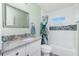 Well-lit bathroom featuring a tub shower with decorative tiling and a granite vanity at 1080 Panda Rd, Venice, FL 34293