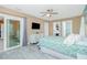 Bright bedroom with a ceiling fan, TV, sliding glass door, and ensuite bath and closet entrances at 1080 Panda Rd, Venice, FL 34293