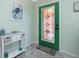 Charming entryway features stylish decor, decorative tile floor, and a vibrant green front door at 1080 Panda Rd, Venice, FL 34293