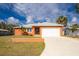 Charming single-story home features an attached garage, well-maintained lawn, and a vibrant, colorful exterior paint at 1080 Panda Rd, Venice, FL 34293