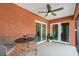 Screened lanai features a ceiling fan, outdoor seating, and sliding glass doors to the interior at 1080 Panda Rd, Venice, FL 34293