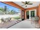 Screened lanai with ceiling fan features a seating area and access to the backyard patio at 1080 Panda Rd, Venice, FL 34293