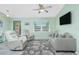 Cozy living room with ample seating, a ceiling fan, a patterned rug, and a view of the front porch at 1080 Panda Rd, Venice, FL 34293
