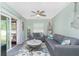 Light and airy living room with a sliding glass door, ceiling fan, and coastal decor at 1080 Panda Rd, Venice, FL 34293