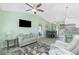 Open-concept living area with a ceiling fan, cozy seating, and a view of the dining area and backyard at 1080 Panda Rd, Venice, FL 34293
