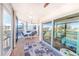 Enclosed lanai featuring a dining set, sliding glass doors, and scenic views of the waterfront at 11000 Placida Rd # 702, Placida, FL 33946