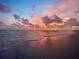 Scenic beach view featuring a vibrant sunset reflecting on the wet sand and gentle ocean waves at 11000 Placida Rd # 702, Placida, FL 33946