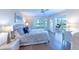Bright bedroom featuring a ceiling fan, wood floors, and access to a private balcony with lovely water views at 11000 Placida Rd # 702, Placida, FL 33946