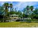 Charming coastal home surrounded by swaying palm trees and a well-manicured lawn at 11000 Placida Rd # 702, Placida, FL 33946