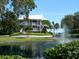 Beautiful condominium with multiple balconies overlooking a serene pond with a fountain and lush landscaping at 11000 Placida Rd # 702, Placida, FL 33946
