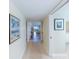 Inviting hallway featuring neutral paint, tile flooring, framed artwork, and views into the living room at 11000 Placida Rd # 702, Placida, FL 33946