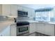 Bright kitchen features white cabinets, stainless steel appliances, quartz counters, and a mosaic tile backsplash at 11000 Placida Rd # 702, Placida, FL 33946
