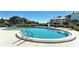 Community pool featuring lounge chairs, lush landscaping, and a glimpse of the ocean and surrounding community at 11000 Placida Rd # 702, Placida, FL 33946